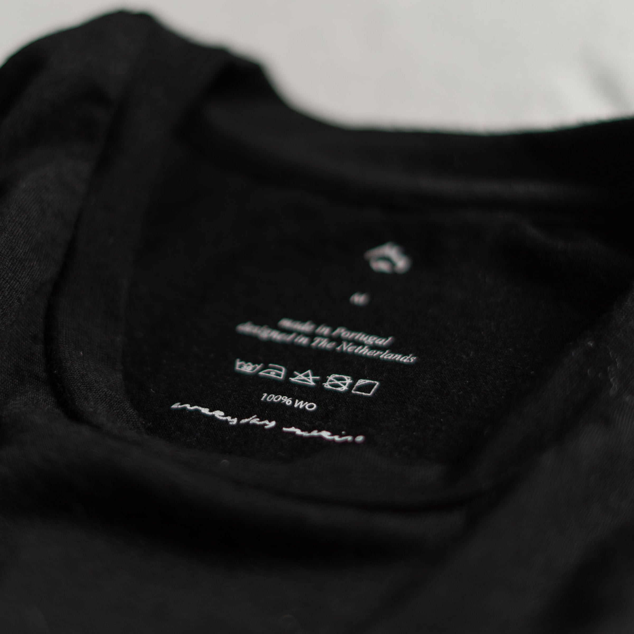 close up of black merino wool t-shirt neck label