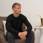 model sitting on chair wearing black merino wool longsleeve