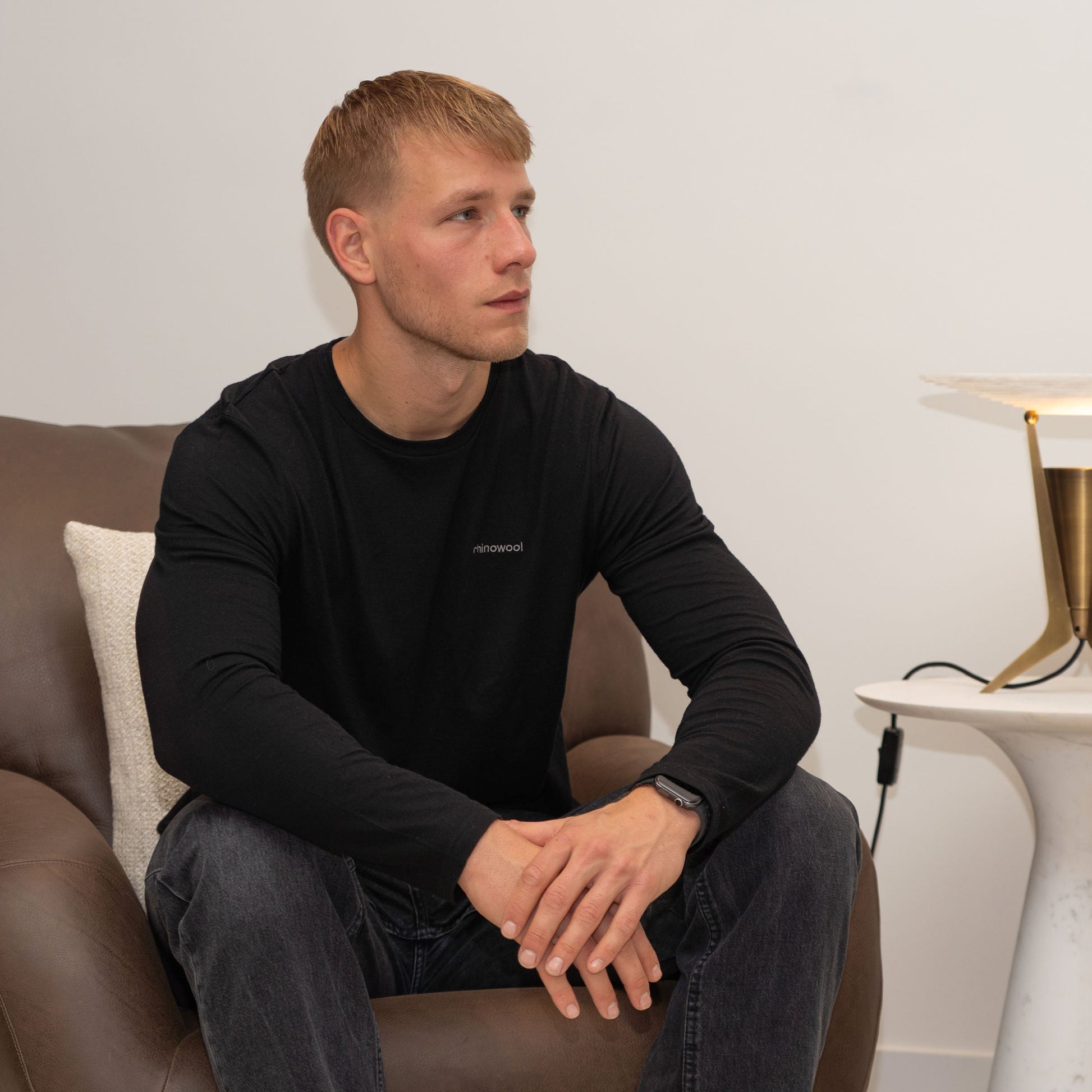 model sitting on chair wearing black merino wool longsleeve