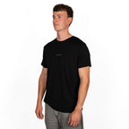 standing model wearing black merino wool t-shirt from side 